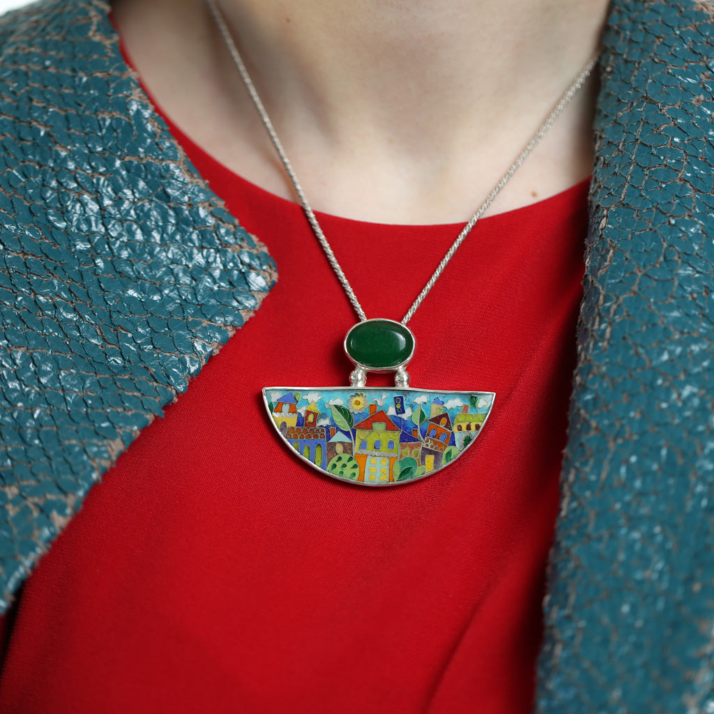 Handmade Enamel Pendant in shape of Half Moon with Natural Green Agata stone, beautiful enamel pattern inspired by picturesque Tbilisi buildings and streets. This pictures shows model's neckline wearing the necklace.